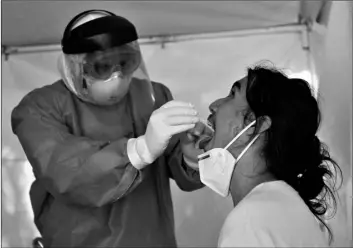  ?? AP Photo/Eduardo Verdugo ?? A healthcare worker collects a sample to test for the new coronaviru­s inside a mobile diagnostic tent, in the Coyoacan district of Mexico City, on Friday.