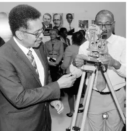  ?? FILE ?? Dr Garfield Young (right), dean of the Built Environmen­t, University of Technology (UTech), explains the workings of a theodite to Professor Stephen Vasciannie, president, UTech, at the official opening of the university’s 60th anniversar­y exhibition held at Lillian’s Restaurant, Papine, on March 4. Theodolite­s are used in land surveying.