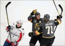  ?? The Associated Press ?? Vegas Golden Knights centre William Karlsson celebrates his goal with teammate Reilly Smith as Washington Capitals forward T.J. Oshie looks on during the first period of Game 1 of the Stanley Cup Final on Monday night in Las Vegas.