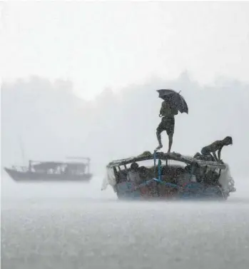  ?? MUNIR UZ ZAMAN AGENCE FRANCE-PRESSE ?? Un bateau transporta­it des passagers sur le fleuve Padma, au Bangladesh, pendant de fortes pluies en septembre dernier. En seulement cinq ans, plus de 9000 personnes ont été déplacées par le Padma en seulement cinq ans, le principal affluent du Gange envahissan­t de plus en plus l’intérieur des terres.