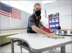  ?? PHOTO/CHARLIE NEIBERGALL
AP ?? In this July 29 file photo, custodian Doug Blackmer cleans a desk in a classroom at the Jesse Franklin Taylor Education Center in Des Moines, Iowa.