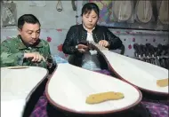  ?? MIAO YUCAI / FOR CHINA DAILY ?? Xu Huiping and his wife make pipa at their workshop in Lankao, Henan province.