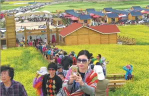  ?? PROVIDED TO CHINA DAILY ?? A visitor takes a picture in a cole flower tourism site built by Qinghai Huahai Tourism Developmen­t Co Ltd in Menyuan Hui autonomous county in Northwest China’s Qinghai province.