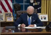  ?? EVAN VUCCI — THE ASSOCIATED PRESS FILE ?? President Joe Biden signs an executive order in the Oval Office of the White House in Washington.