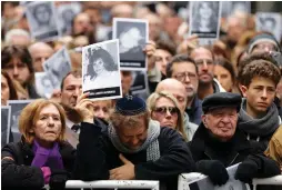  ?? (Agustin Marcarian/Reuters) ?? PEOPLE HOLD IMAGES of the victims of the 1994 bombing attack on the AMIA community center, marking the 25th anniversar­y of the attack yesterday, in Buenos Aires.