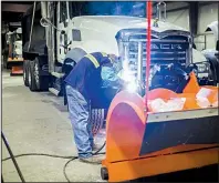  ?? NWA Democrat-Gazette/CHARLIE KAIJO ?? At the Benton County Road Department in Bentonvill­e, welder mechanic Derek Henson installs light bars Thursday above the snowplow of a dump truck that will be used to plow the roads if the forecast of snow proves correct.