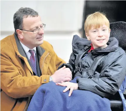 ??  ?? > Daniel Spencer, 13, was awarded a settlement worth £6.5 million – pictured with father Oliver Spencer