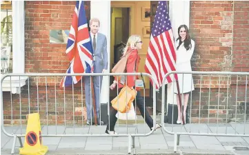  ??  ?? A pedestrian walks past cut-out figures of Prince Harry and Meghan in Windsor on Thursday, two days before the royal wedding. (Below) A carriage takes part in rehearsals for the wedding on Thursday. — AFP/Reuters photos