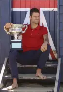  ??  ?? Djokovic poses with the trophy