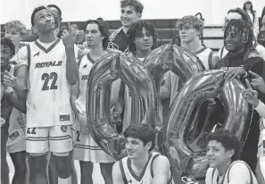  ?? MIKE CARDEW/AKRON BEACON JOURNAL ?? Darryn Peterson holds up his index finger as he looks up to the ceiling at the No. 1 balloon as he poses for photos to celebrate his 1,000th point after a win over Northwest.