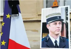  ?? BERTRAND GUAY / AFP / GETTY IMAGES ?? A portrait of French Lt.- Col. Arnaud Beltrame at a memorial service in Paris on March 28.