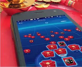  ??  ?? Attraper des enveloppes rouges d’étrennes sur son smartphone : un nouveau divertisse­ment au Nouvel An chinois.