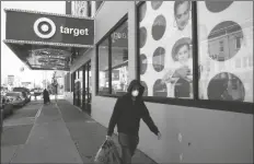  ?? ASSOCIATED PRESS ?? IN THIS APRIL 6 FILE PHOTO, a customer wearing a mask carries his purchases as he leaves a Target store in the Brooklyn borough of New York. Target has joined a growing list of major retailers that will require customers at all their stores to wear face coverings. The Minneapoli­s, Minn.-based discounter said Thursday that the policy will go into effect Aug. 1.