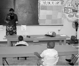  ?? BUCKNOR PHOTO BY HOPETON ?? Susan Davis, principal of the St James-based Sudbury All-Age and Infant School, interactin­g with some of her students during a class on Monday as the institutio­n reopened for face-to-face classes.