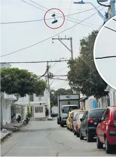  ?? FOTOS JOHN ROBLEDO Y 123RF ?? Calle de uno de los barrios del surocciden­te de Barranquil­la donde se ven colgados dos tenis de color negro en uno de los cables de energía.