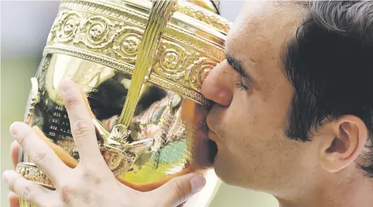  ?? Picture: AFP ?? MASTERFUL. Switzerlan­d’s Roger Federer kisses the trophy after beating Croatia’s Marin Cilic in the Wimbledon final yesterday.