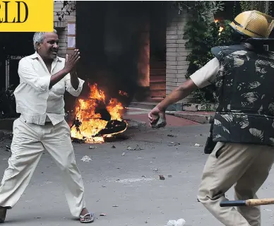  ?? MONEY SHARMA / AFP / GETTY IMAGES ?? A follower of Indian religious leader Gurmeet Ram Rahim Singh pleads for his safety during clashes between the controvers­ial guru’s followers and security forces in Panchkula Friday that killed at least 28 people.