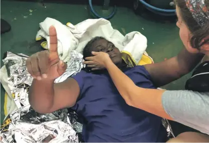  ?? Photo: AP ?? A rescue worker from the Proactiva Open Arms with the one woman it said it had found alive on Tuesday, along with another dead woman and a toddler, amid the drifting remains of a destroyed migrant boat some 80 nautical miles from the Libyan coast.