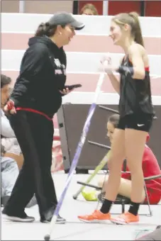  ?? Photograph by John McGee ?? Coach Heather Wade and Lady Blackhawk senior Cassidy Mooneyhan visit before Mooneyhan went on to win her second gold medal in the pole vault Friday.