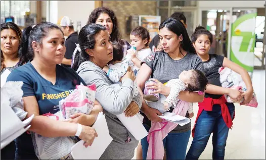  ??  ?? Immigrants wait to head to a nearby Catholic Charities relief center after being dropped off at a bus station shortly after release from detention through ‘catch and release’ immigratio­n policy on June 17, in McAllen, Texas. The man said he was...