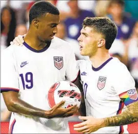  ?? Jeff Dean Associated Press ?? CHRISTIAN PULISIC, with Haji Wright, wears a rainbow armband. For the World Cup, the crest on U.S. kits will have rainbow stripes below the USA letters.