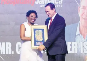  ?? PHOTO BY ASHLEY ANGUIN ?? RJRGLEANER Hospitalit­y Jamaica Hospitalit­y Personalit­y of the Year, Chris Issa accepts the award from Janet Silvera, coordinato­r of Hospitalit­y Jamaica.