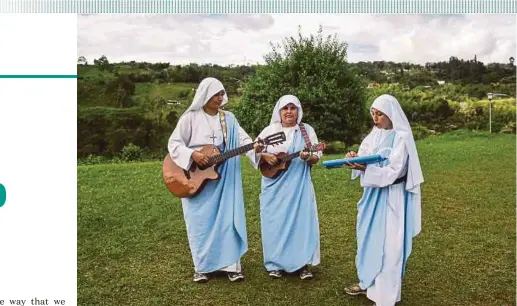  ?? AFP PIC ?? Nun Maria Valentina de los Angeles (centre) with two other nuns playing instrument­s during the recording of a video at a convent in the outskirts of Cali, Colombia, on July 17.