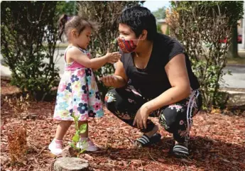  ?? PAT NABONG/SUN-TIMES ?? Xochitl, 2, gives a leaf to her mom, Katsumi “Kitty” Perez, 19, at Warren Park.