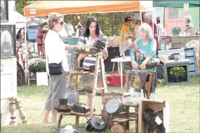  ?? FILE PHOTOS ?? Janice Hughes, left, with the Gilded Passion vendor tent from Smackover talks to customers about her items for sale during the fall 2017 show of The Junk Ranch, located just outside Prairie Grove city limits. Thousands of people, mainly women, shop at The Junk Ranch during its June and October shows.