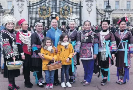 ?? PHOTOS PROVIDED TO CHINA DAILY ?? Embroidere­rs pose outside Buckingham Palace as they see the sights in London on Dec 7 during an exhibition of their traditiona­l handicraft­s.
