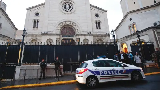  ?? (Reuters) ?? ARMED FRENCH soldiers and a police car stand in front of a Synagogue during a visit of French Interior Minister Bernard Cazeneuve after an attack at a Jewish school in Marseille in 2016.