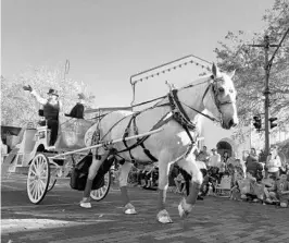  ?? MARCO SANTANA/STAFF ?? A horse-drawn carriage — complete with a bride — represents the Winter Park Wedding Chapel during the Christmas parade Saturday on Park Avenue in downtown Winter Park.