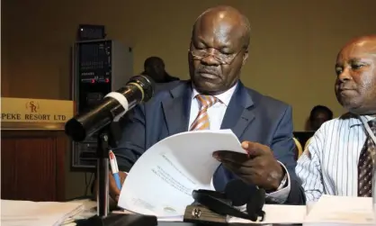  ?? Photograph: Isaac Kasamani/AFP/Getty ?? Roger Lumbala, signs documents before a press briefing in Kampala in 2013.