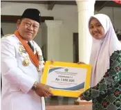  ?? LUDRI PRAYOGA/JAWA POS ?? APRESIASI PRESTASI: Bupati Saiful Ilah menyerahka­n uang pembinaan kepada Kharisma Aliviah sebagai salah satu peraih nilai unas tertinggi.