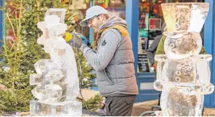  ?? CONTRIBUTE­D ?? Ian Drummond carves an ice sculpture at last year’s Victorian Christmas Market. Drummond will be back again this year on Nov. 28-29.