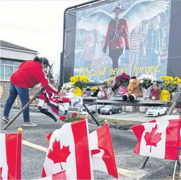  ?? SALTWIRE NETWORK PHOTO ?? A woman places flowers at a memorial in Cole Harbour, N.S., on Friday.