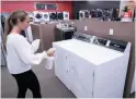  ?? PAUL CHIASSON THE CANADIAN PRESS ?? A sales clerk sanitizes appliances at a furniture store in St-Jean-surRicheli­eu, Que., Monday as the province relaxed restrictio­ns on retail shopping.