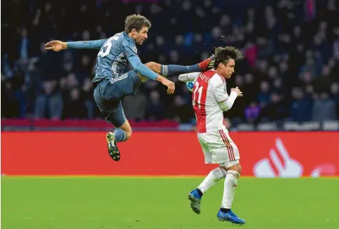  ?? Foto: Emmanuel Dunand, afp ?? Sieht nicht nach Fußball aus: Thomas Müller trifft beim Versuch, den Ball zu erreichen, den Kopf von Nicolas Tagliafico. Für diese Aktion sah der Münchner Rot. Er wird damit in jedem Fall für das erste Viertelfin­alspiel gesperrt sein.