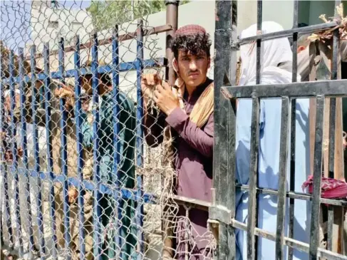  ??  ?? Afghan people wait at Torkhamb order crossing to enter Pakistan (Anadolu Agency/ Getty)