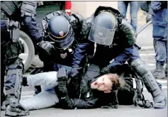 ??  ?? French CRS riot police apprehend a man in a street near Saint Lazare train station during a national day of protest in Paris. — Reuters photo