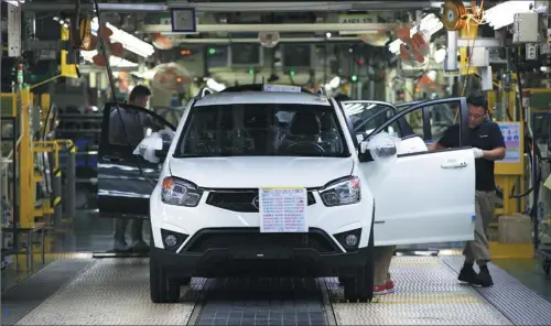  ?? CHO SEONG-JOON / BLOOMBERG VIA GETTY IMAGES ?? Employees check a Ssangyong Motor Korando C SUV during final inspection on the production line at the company’s factory in Pyeongtaek, South Korea, in August 2014.