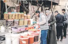  ?? ?? People buy olives and pickled vegetables in Gaza City.