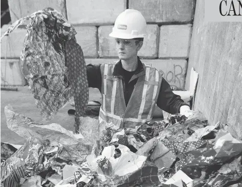  ?? DAVID BLOOM / POSTMEDIA NEWS / QMI AGENCY FILES ?? Alyson Winkelaar of Edmonton Waste Management Services shows some of the metallic wrapping paper that shouldn’t go in blue recycle bins.