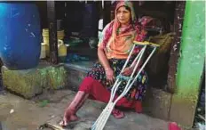  ?? AFP ?? Nilofer Begum, an injured garment worker, sits with her crutches by her small tea stall in Savar, near Dhaka.