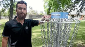  ?? BEJON HASWELL/STUFF ?? South Canterbury Disc Golf Club president Chris Smith leans on a disc golf basket at West End Park.