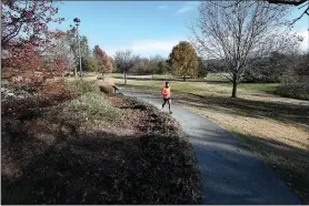  ?? NWA Democrat-Gazette/J.T. WAMPLER ?? A jogger uses the trail at Gulley Park on Nov. 21.