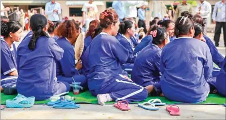  ?? VIREAK MAI ?? Prisoners sit in the courtyard of Prey Sar prison.