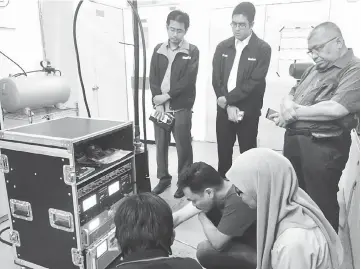  ??  ?? Technician­s conduct a final equipment check prior to the trial broadcast.