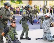  ?? Adolphe Pierre-Louis Associated Press ?? ALBUQUERQU­E police detain members of the New Mexico Civil Guard, an armed civilian militia group.