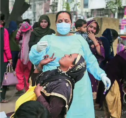  ?? AP ?? Una enfermera realiza un test de detección de la covid a una mujer en Jammu, India